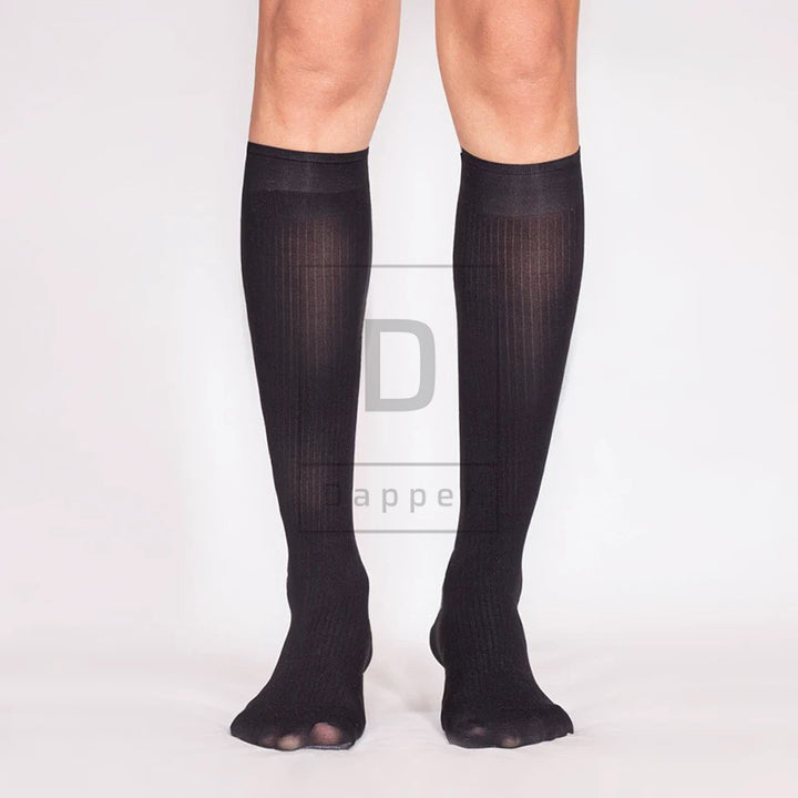 Front view of black Striped Luxe dress socks worn on the legs, showing fine vertical stripes and wide cuffs